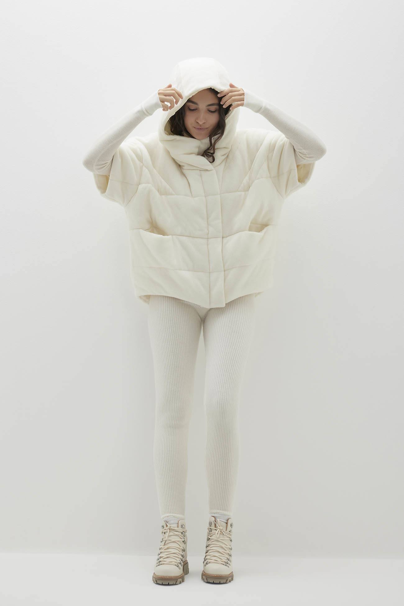 Model wearing stylish outerwear, featuring an oversized cream hooded jacket with matching leggings.