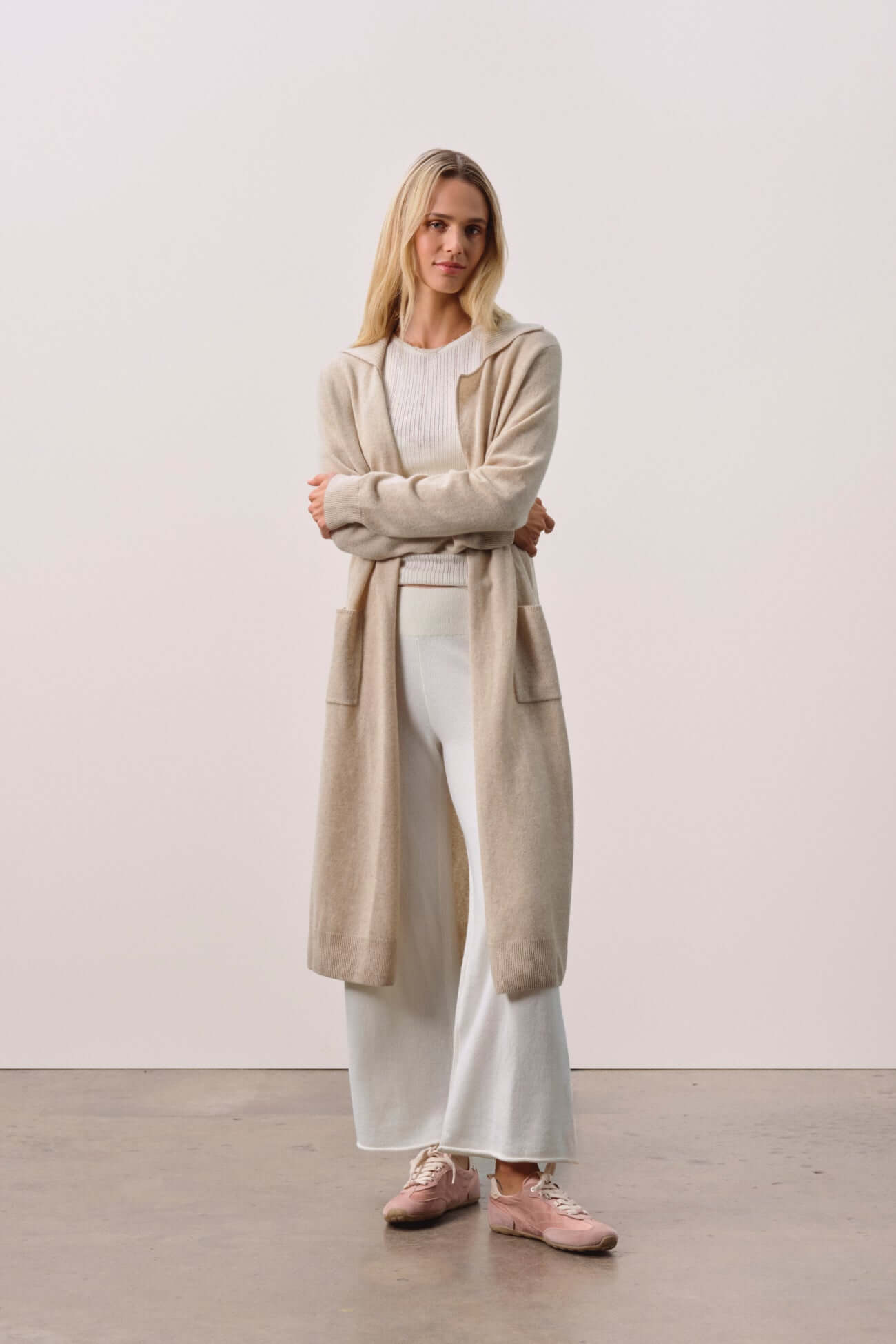 Woman wearing a stylish cardigan over a white outfit. Cardigans collection showcase.
